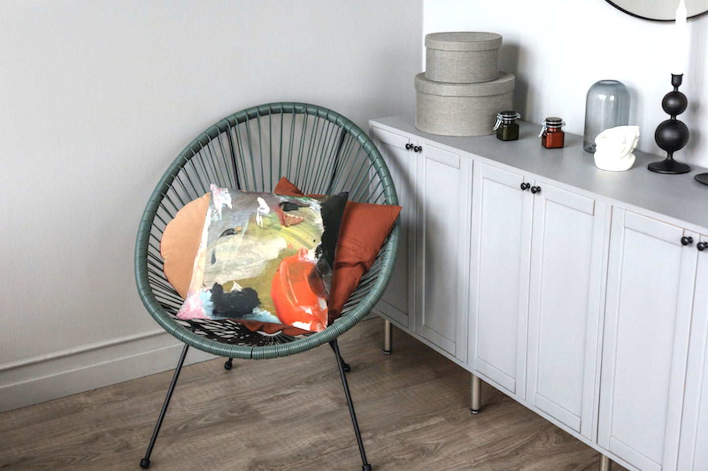 Pinnacle abstract art accent cushion featuring bold coral-orange brushstroke, soft pinks, emerald green, charcoal black, and pale blue on textured gray background