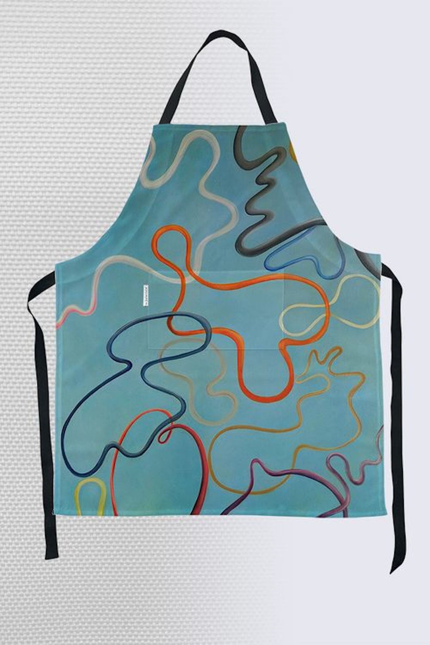 Modern abstract art apron with playful wavy lines in teal, orange, navy, and cream on turquoise background with black straps and front pocket