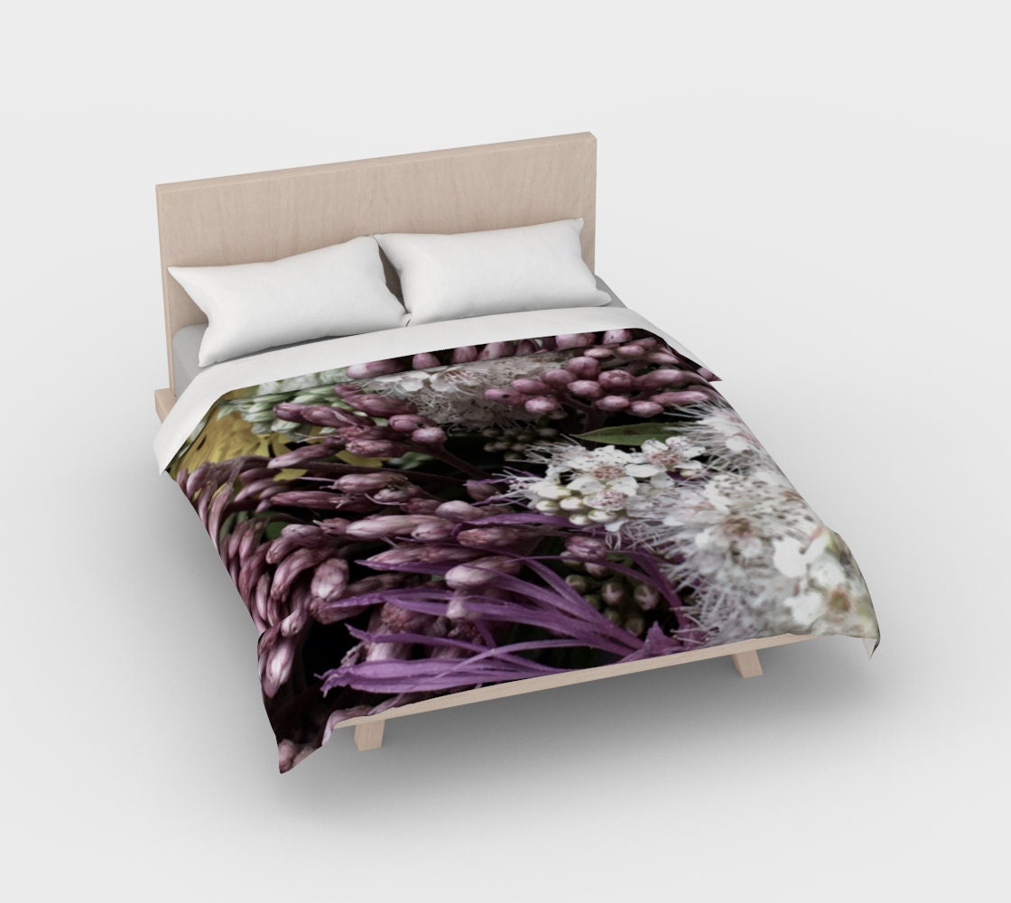 Bed of Flowers duvet cover reverse side on bed showing cascading purple hyacinth blooms with deep violet leaves, white starburst flowers, and pale green buds