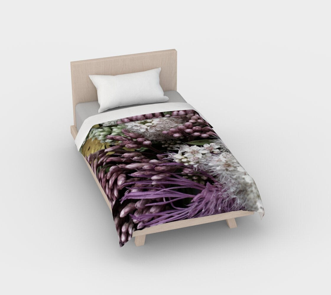 Bed of Flowers duvet cover on twin bed showing full botanical composition with purple hyacinths, deep violet leaves, white starburst flowers, and chartreuse buds