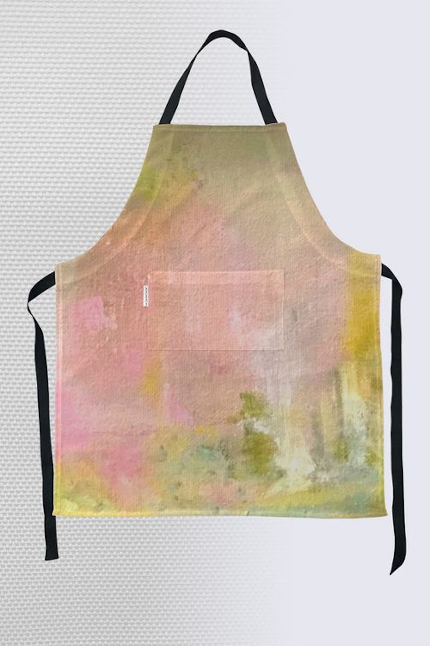 Abstract watercolor art apron in soft pink, sage green, and yellow with black straps and front pocket
