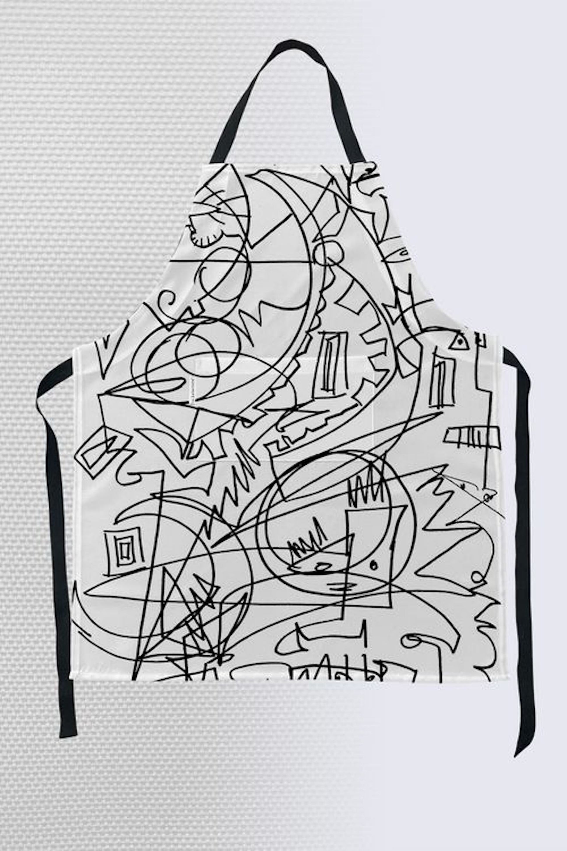 Minimalist black and white abstract line art apron with geometric shapes and expressive scribbles with front pocket and black straps