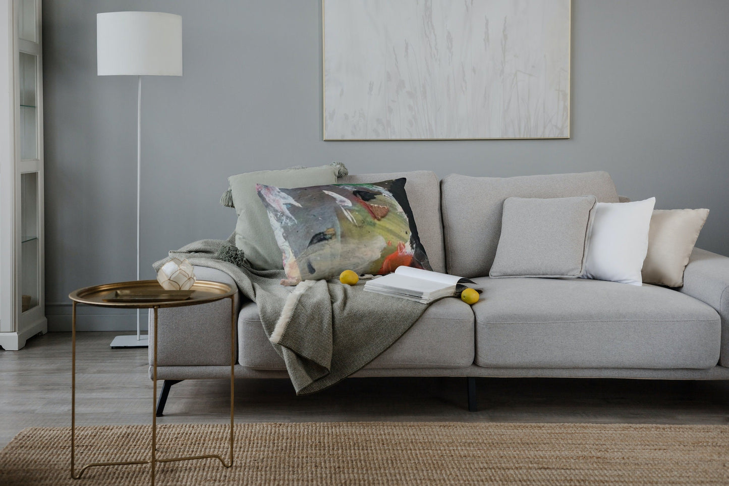 Pinnacle abstract art accent cushion featuring bold coral-orange brushstroke, soft pinks, emerald green, charcoal black, and pale blue on textured gray background